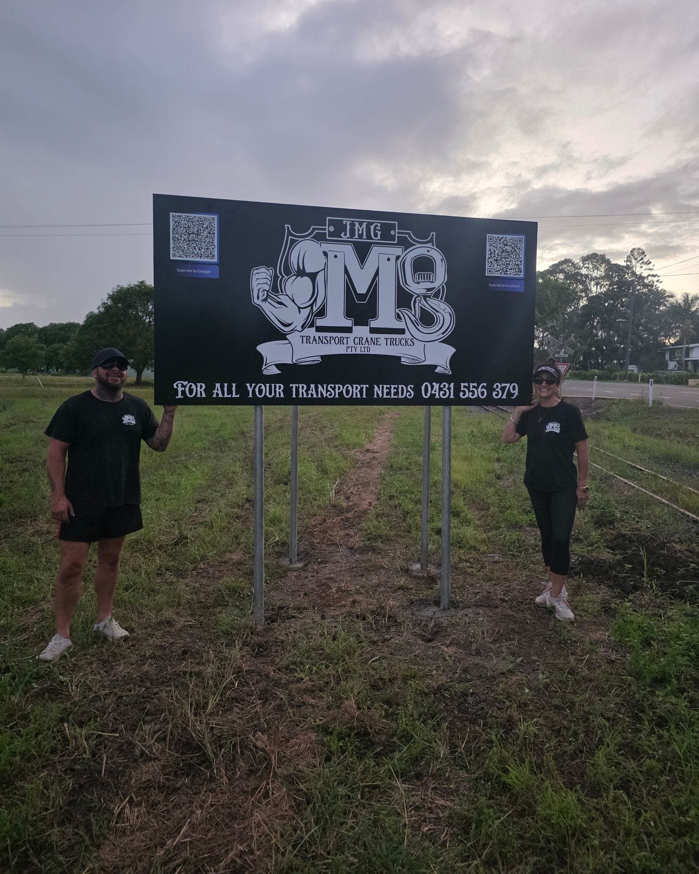 Jason and Rebecca at the JMG Transport & Crane Trucks signage outside the Pleystowe yard