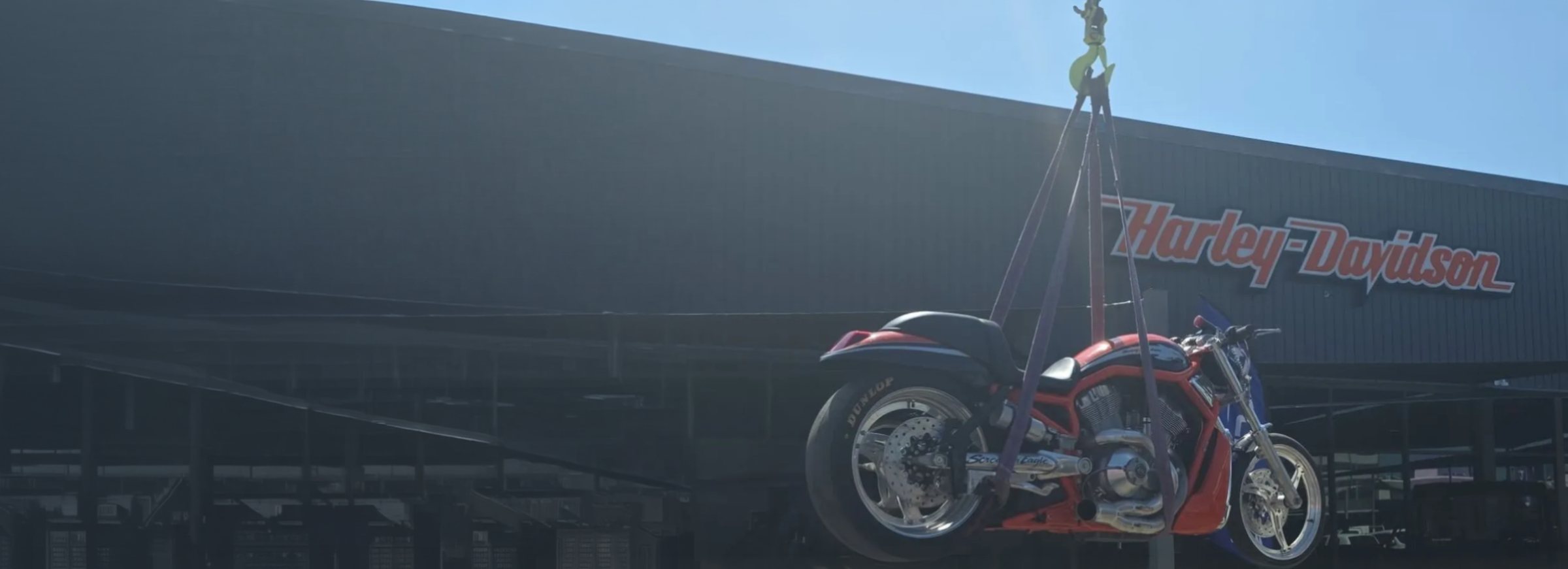 JMG Transport craning a Harley-Davidson V-Rod motorcycle off the flatbed at a Mackay dealership