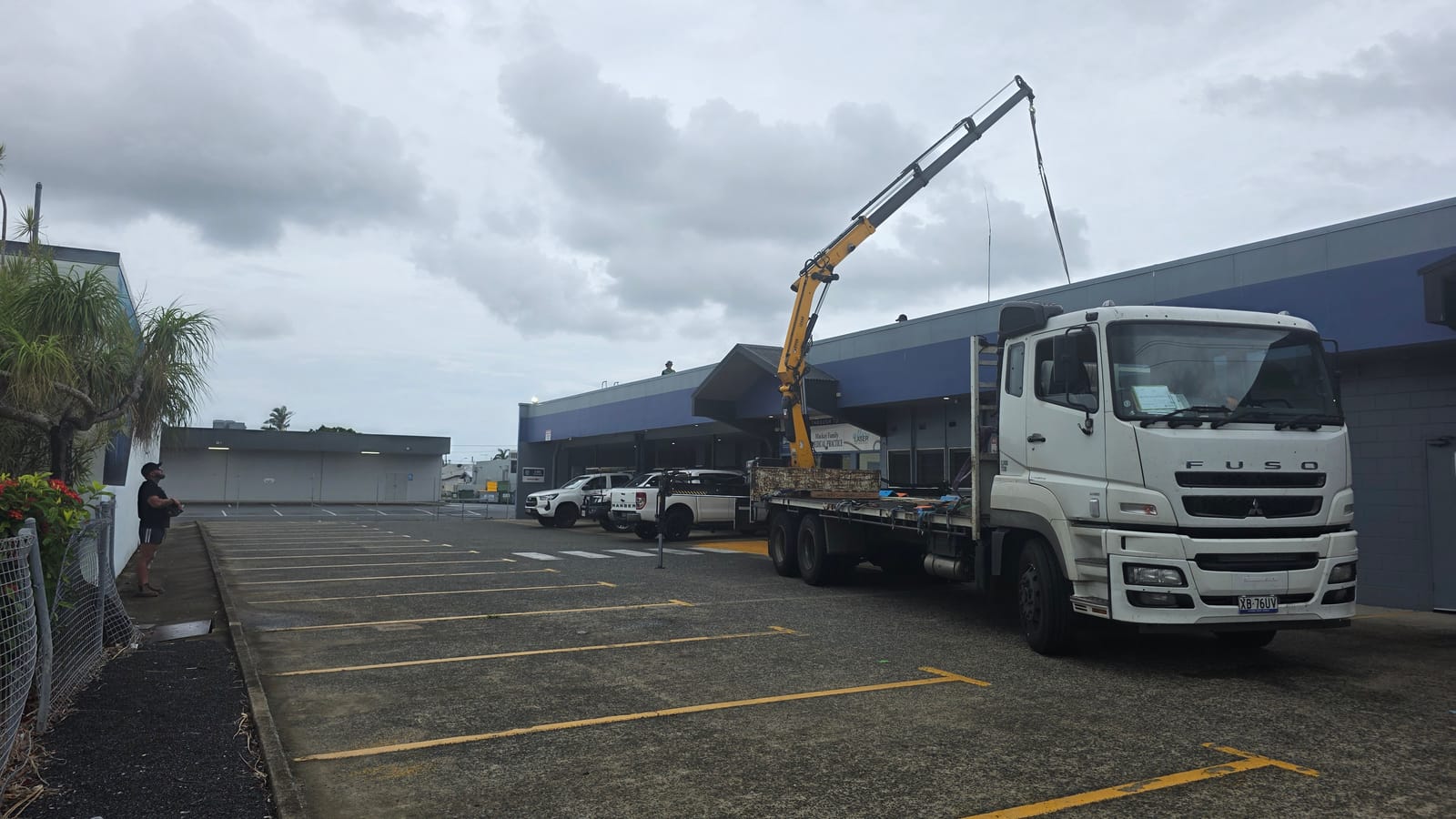 JMG Transport 12-tonne flatbed crane truck parked at a Mackay worksite